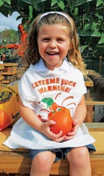 Emma enjoys a Honeybell while playing in the O.J. Corral at Al's